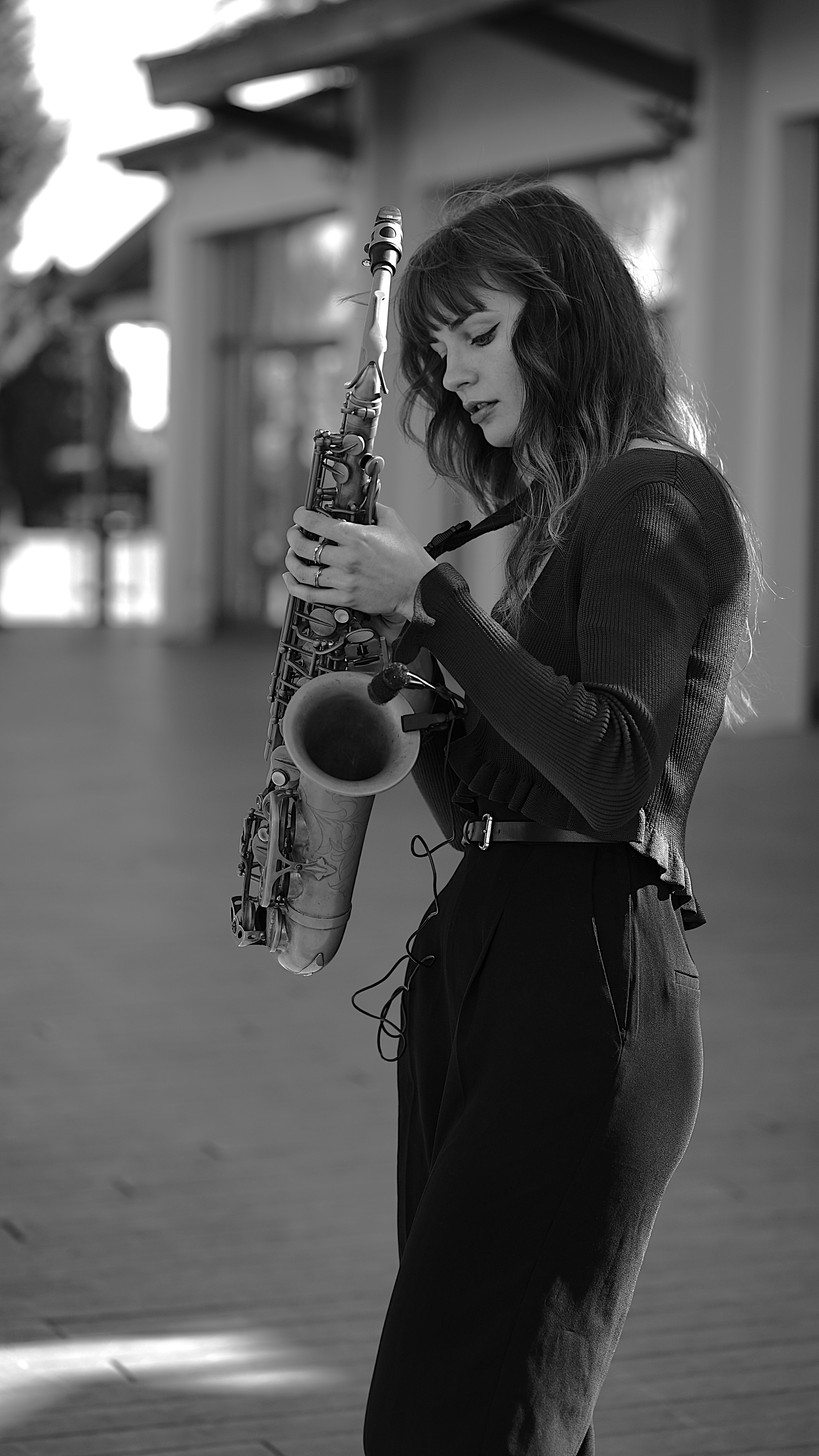 Kristína in a quiet architectural interior, saxophone in hand